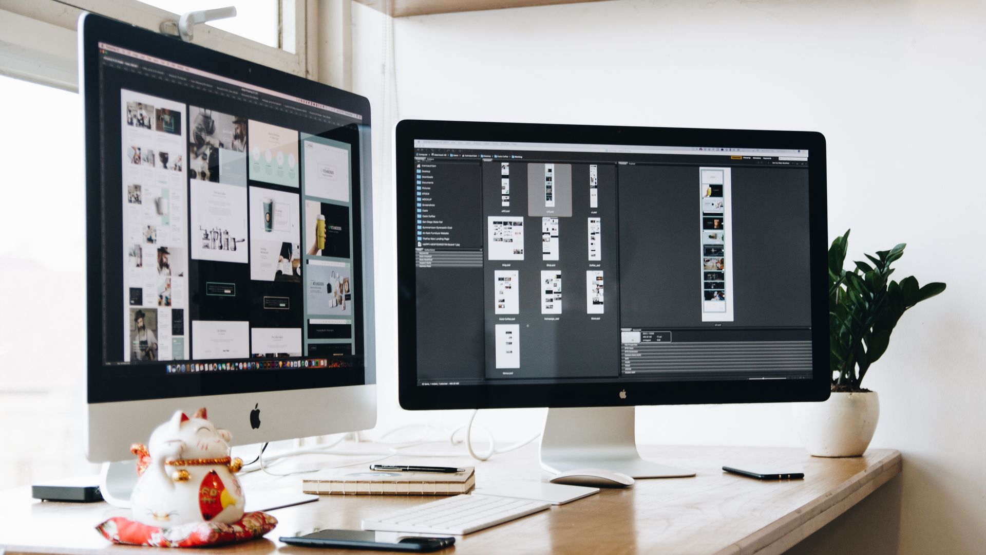 Espace de travail moderne avec écrans, clavier, carnets et plante décorative.